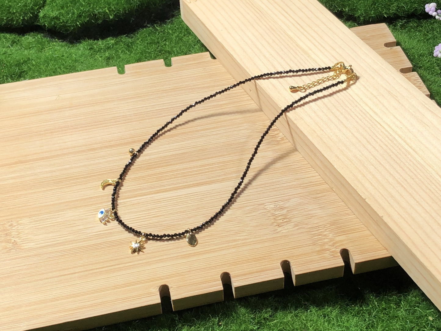 Eine handgefertigte Halskette aus natürlichem schwarzem Spinell mit fünf 14-karätig vergoldeten Kupferanhängern.
