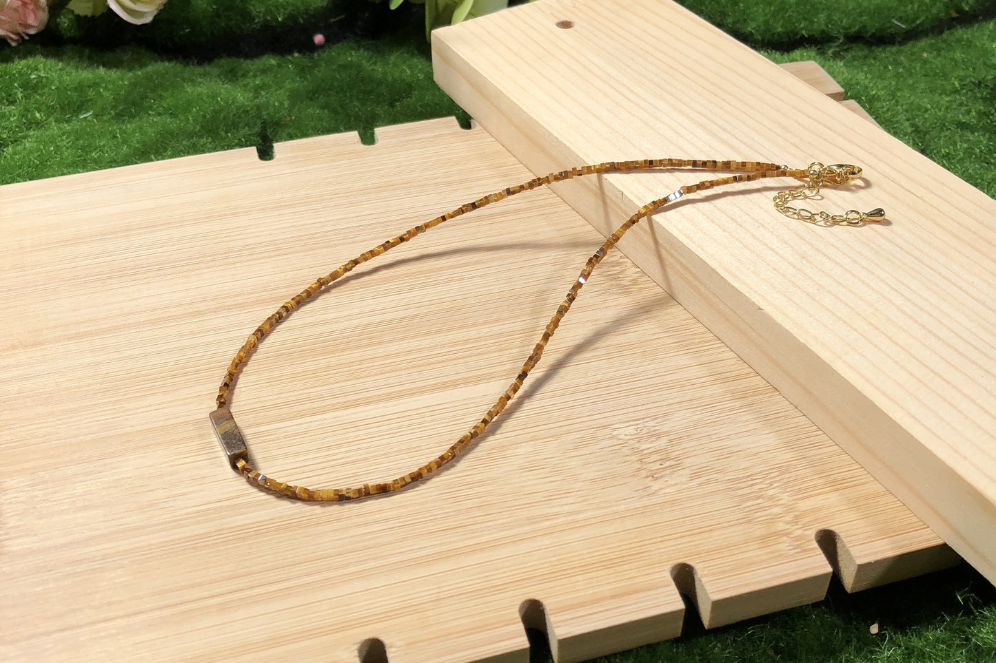 Dieses handgefertigte Schmuckstück besteht aus quadratischen Perlen aus natürlichem Tigerauge und einem rechteckigen Anhänger aus quadratischen Perlen.