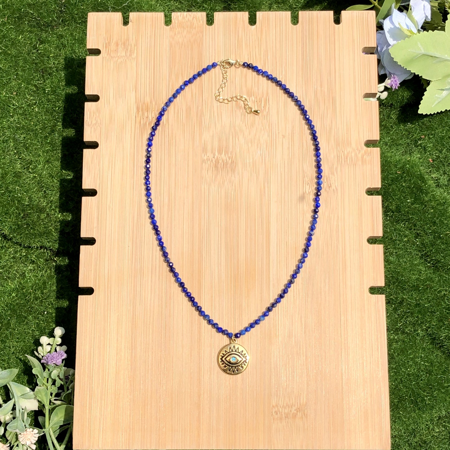 Halskette mit Anhänger in Form des Bösen Blicks aus Lapislazuli, Kette aus Titanstahl, 14 Karat vergoldet.