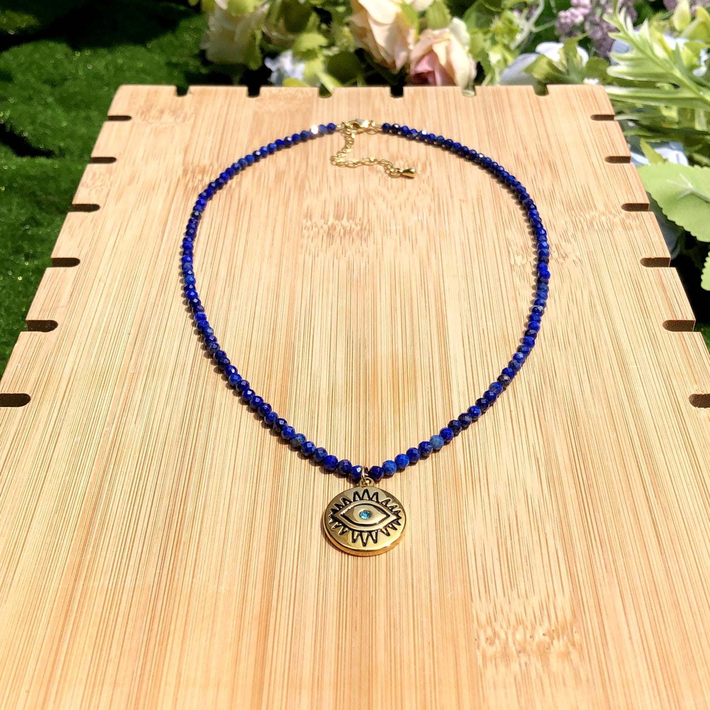 Halskette mit Anhänger in Form des Bösen Blicks aus Lapislazuli, Kette aus Titanstahl, 14 Karat vergoldet.