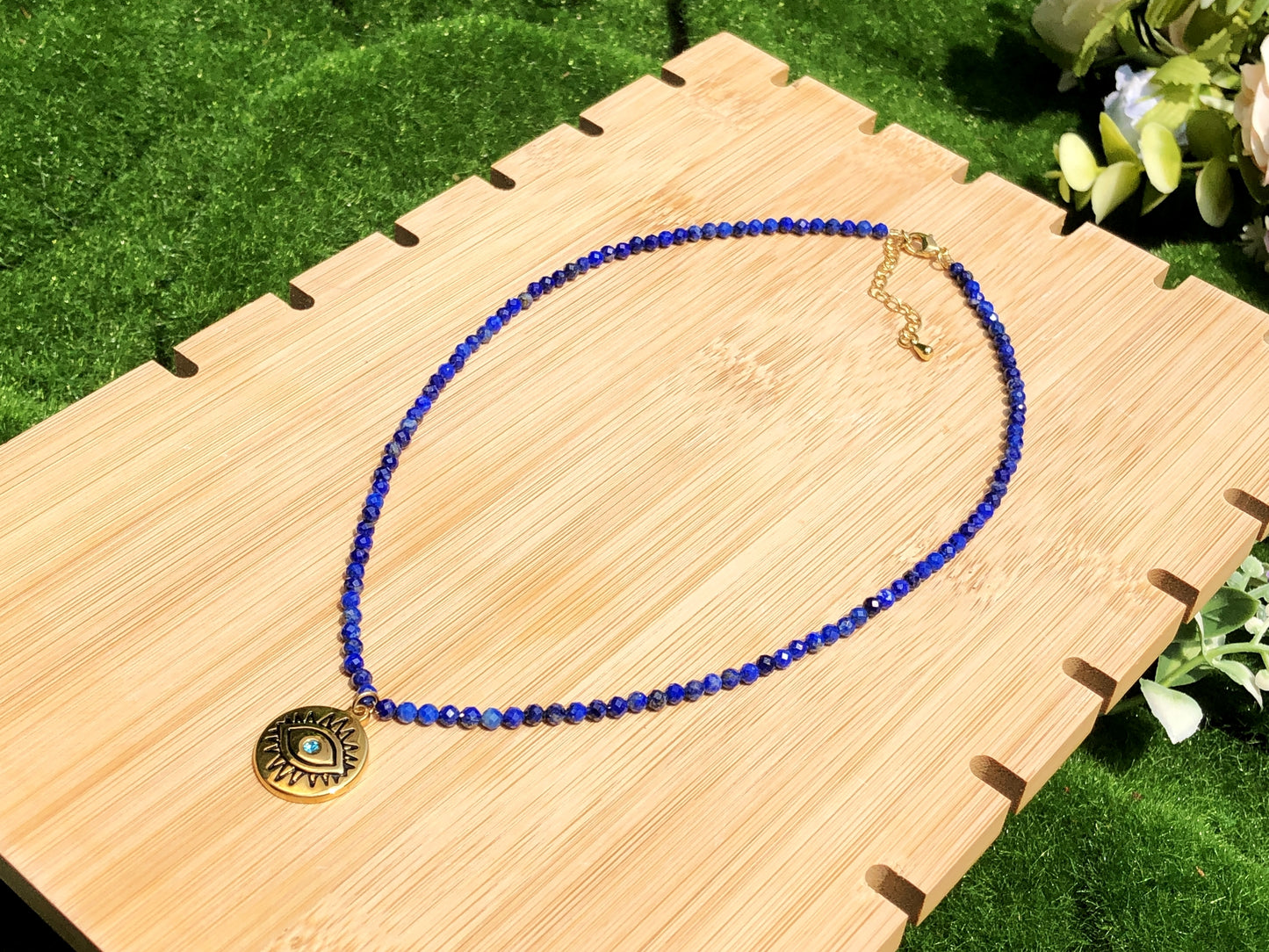 Halskette mit Anhänger in Form des Bösen Blicks aus Lapislazuli, Kette aus Titanstahl, 14 Karat vergoldet.