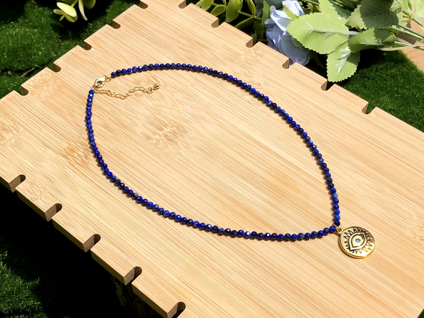Halskette mit Anhänger in Form des Bösen Blicks aus Lapislazuli, Kette aus Titanstahl, 14 Karat vergoldet.