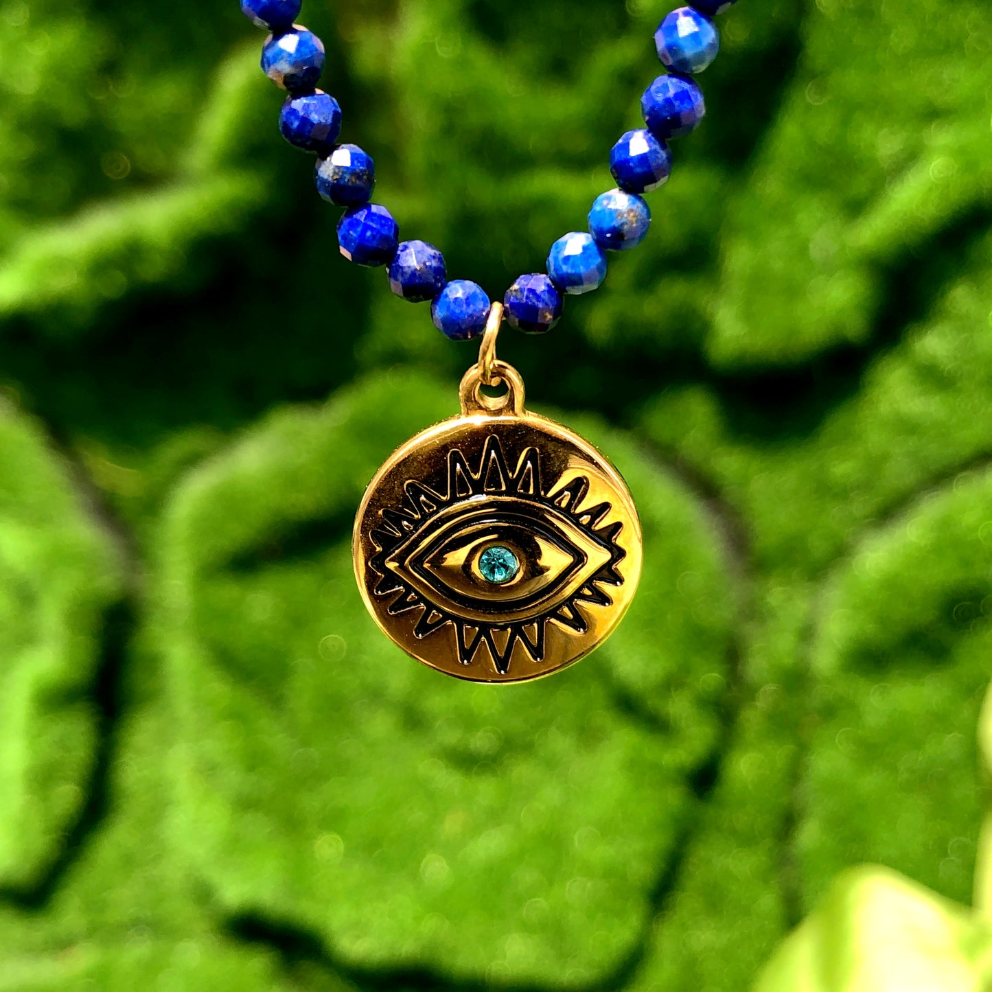 Halskette mit Anhänger in Form des Bösen Blicks aus Lapislazuli, Kette aus Titanstahl, 14 Karat vergoldet.