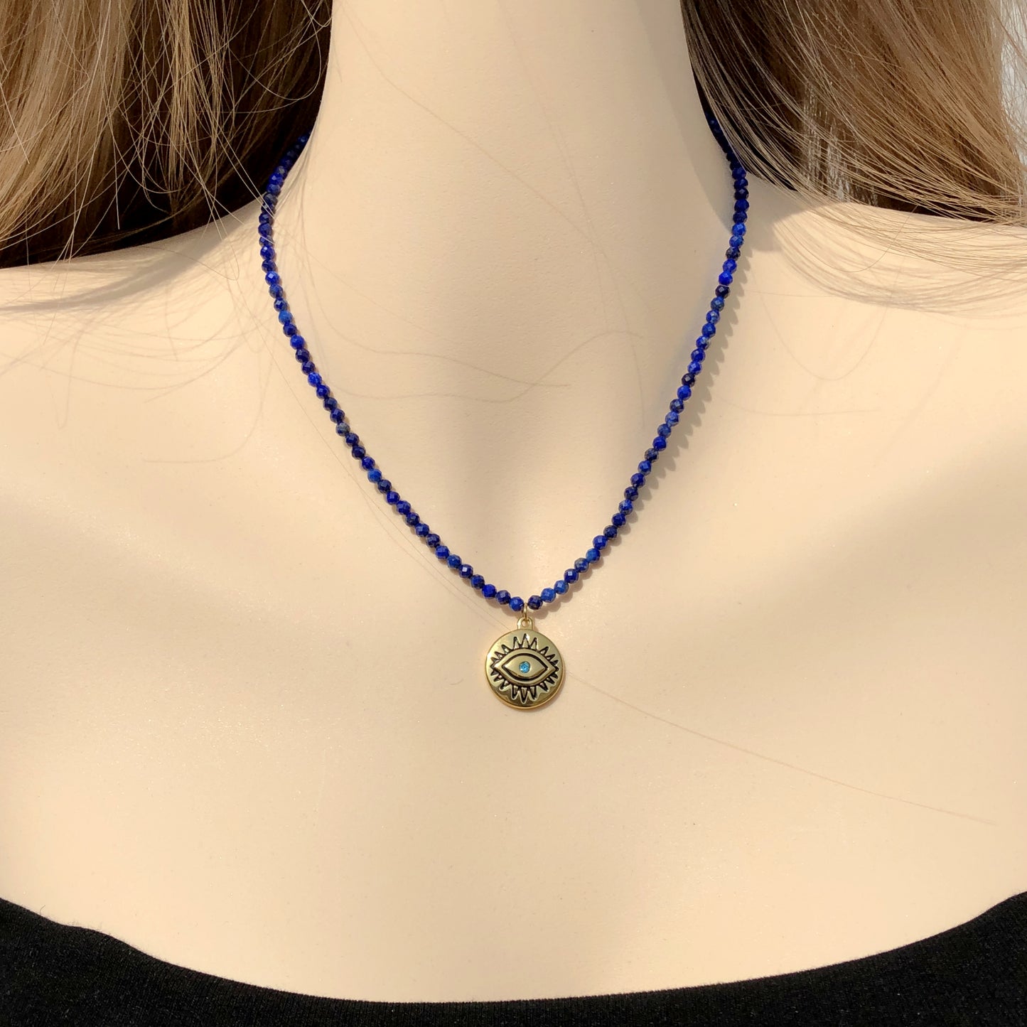Halskette mit Anhänger in Form des Bösen Blicks aus Lapislazuli, Kette aus Titanstahl, 14 Karat vergoldet.