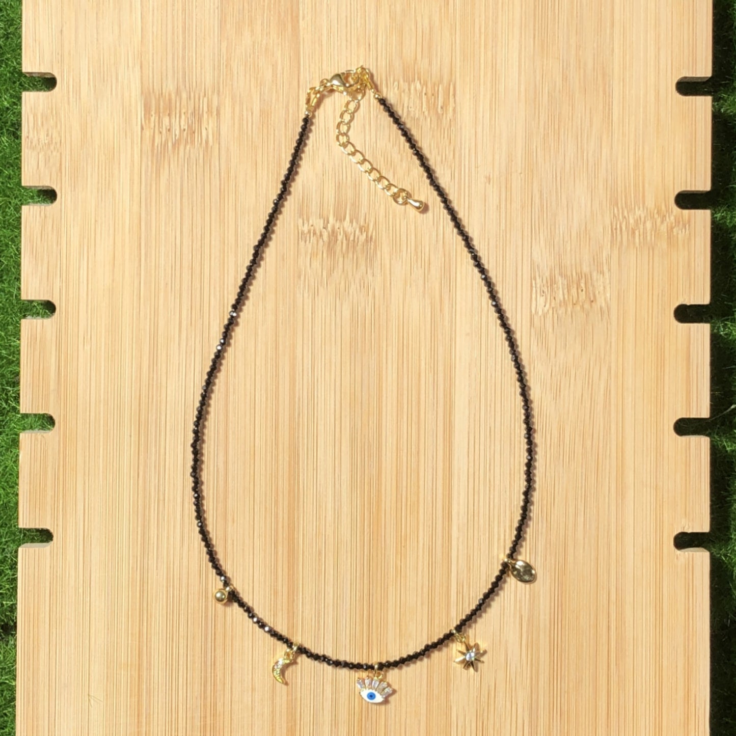 Eine handgefertigte Halskette aus natürlichem schwarzem Spinell mit fünf 14-karätig vergoldeten Kupferanhängern.