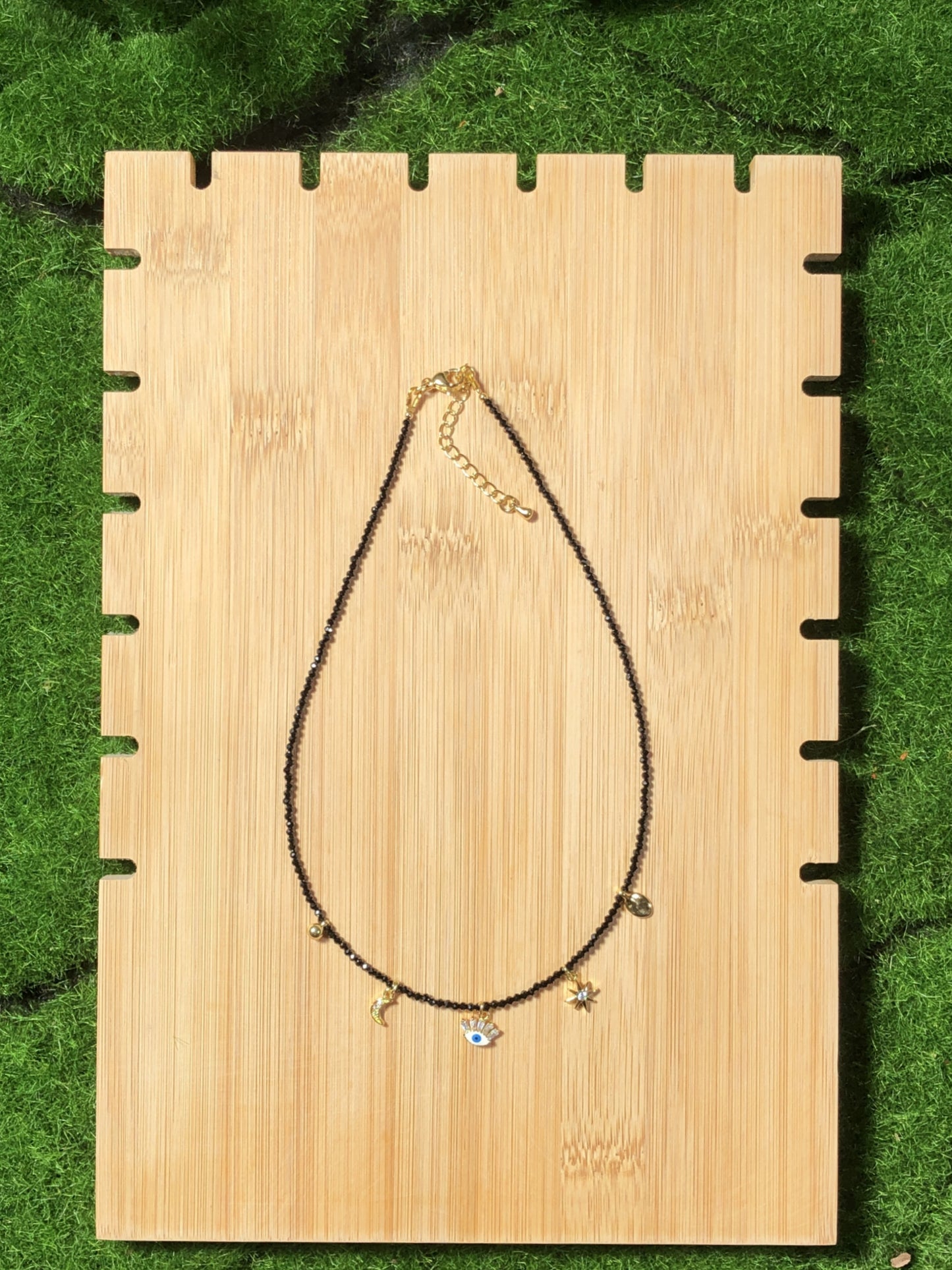 Eine handgefertigte Halskette aus natürlichem schwarzem Spinell mit fünf 14-karätig vergoldeten Kupferanhängern.