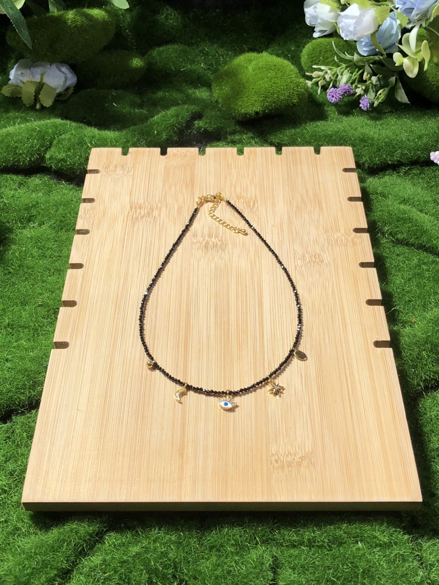 Eine handgefertigte Halskette aus natürlichem schwarzem Spinell mit fünf 14-karätig vergoldeten Kupferanhängern.