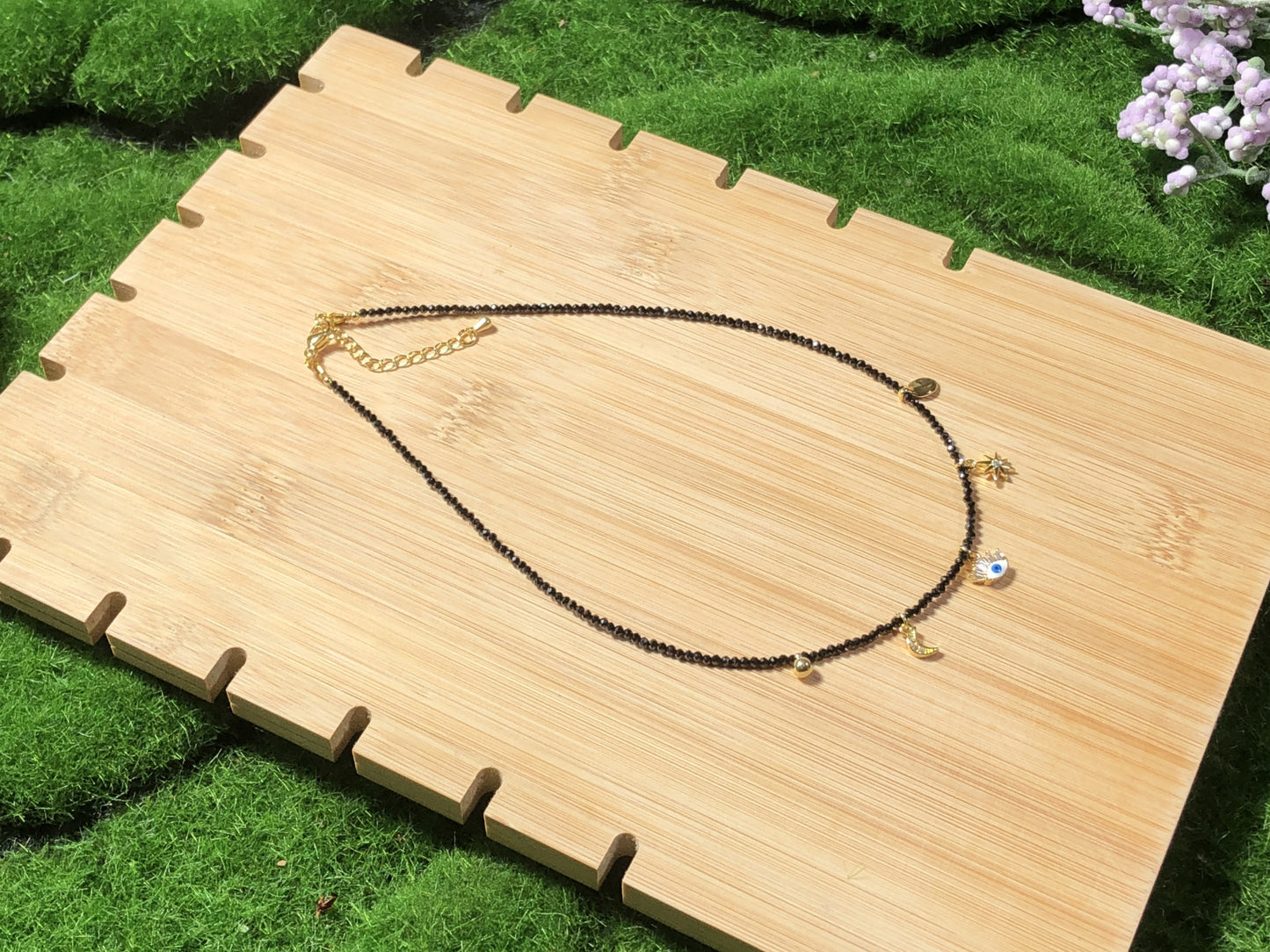 Eine handgefertigte Halskette aus natürlichem schwarzem Spinell mit fünf 14-karätig vergoldeten Kupferanhängern.
