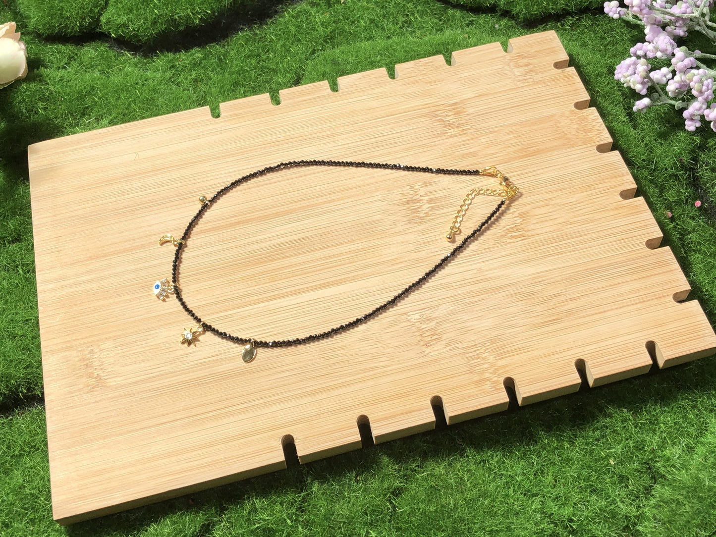 Eine handgefertigte Halskette aus natürlichem schwarzem Spinell mit fünf 14-karätig vergoldeten Kupferanhängern.