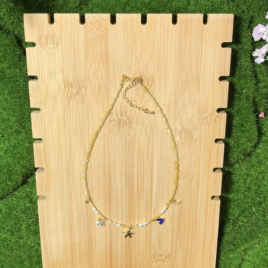 Eine handgefertigte Halskette aus natürlichem Citrin und Süßwasserperlen mit einem Anhänger aus 14-karätig vergoldetem Kupfer.