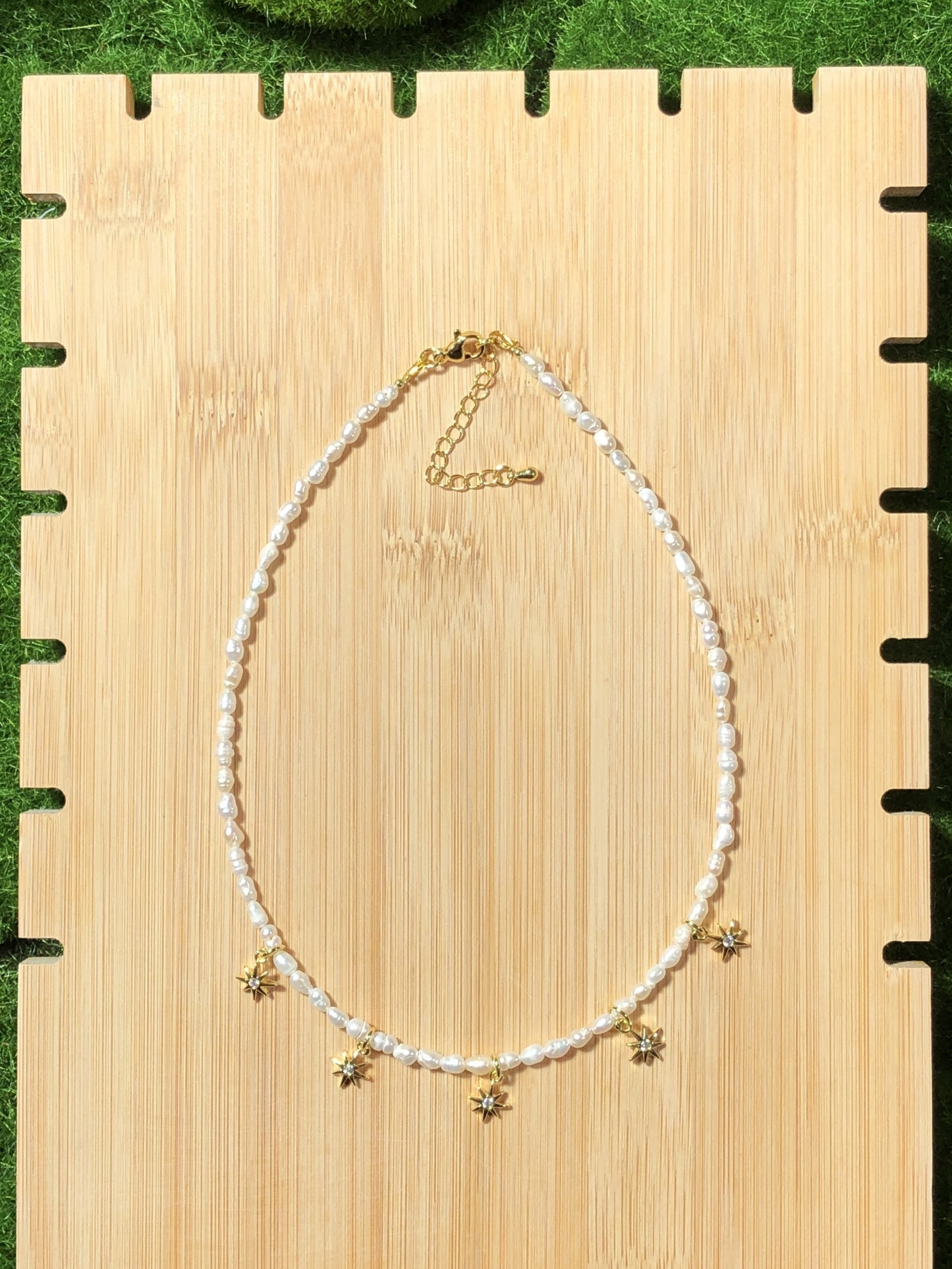 Eine handgefertigte Halskette aus natürlichen Süßwasserperlen mit einem 14-karätig vergoldeten Kupfer-Sonnenanhänger.