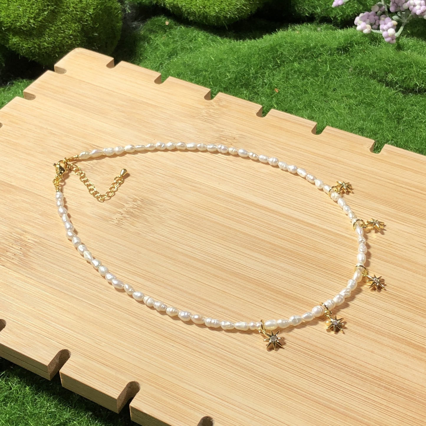 Eine handgefertigte Halskette aus natürlichen Süßwasserperlen mit einem 14-karätig vergoldeten Kupfer-Sonnenanhänger.