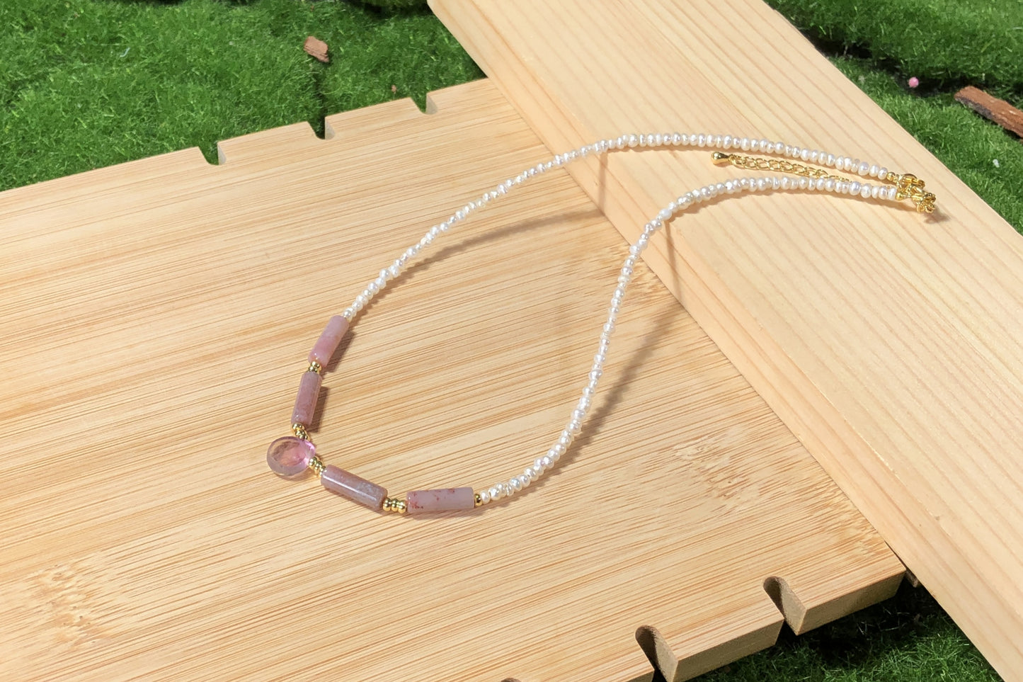 Eine handgefertigte Halskette aus natürlichen Süßwasserperlen und Achat mit einer Kette aus 14-karätig vergoldetem Messing.