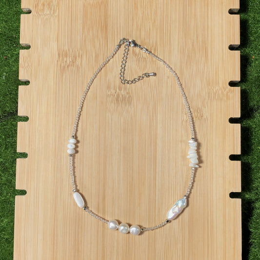 Handgefertigte Halskette aus natürlichen Süßwasserperlen und Muscheln.
