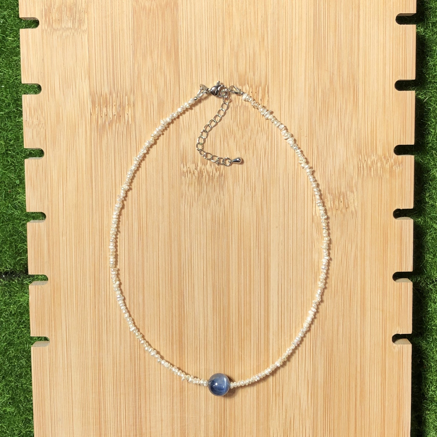 Eine handgefertigte Halskette aus natürlichen Süßwasserperlen und blauen Kristallen, aus mit 14-karätigem Gold plattiertem Kupfer.