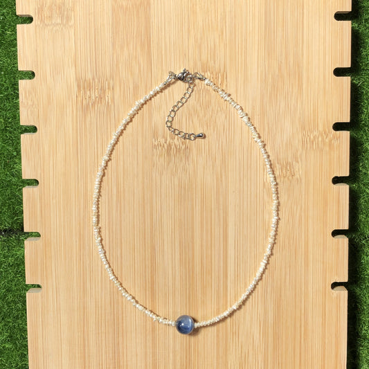 Eine handgefertigte Halskette aus natürlichen Süßwasserperlen und blauen Kristallen, aus mit 14-karätigem Gold plattiertem Kupfer.