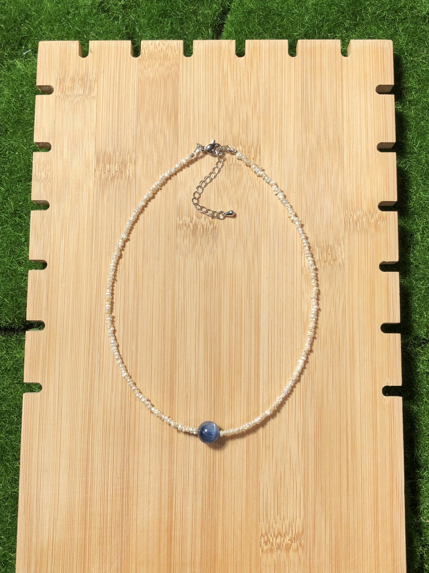 Eine handgefertigte Halskette aus natürlichen Süßwasserperlen und blauen Kristallen, aus mit 14-karätigem Gold plattiertem Kupfer.