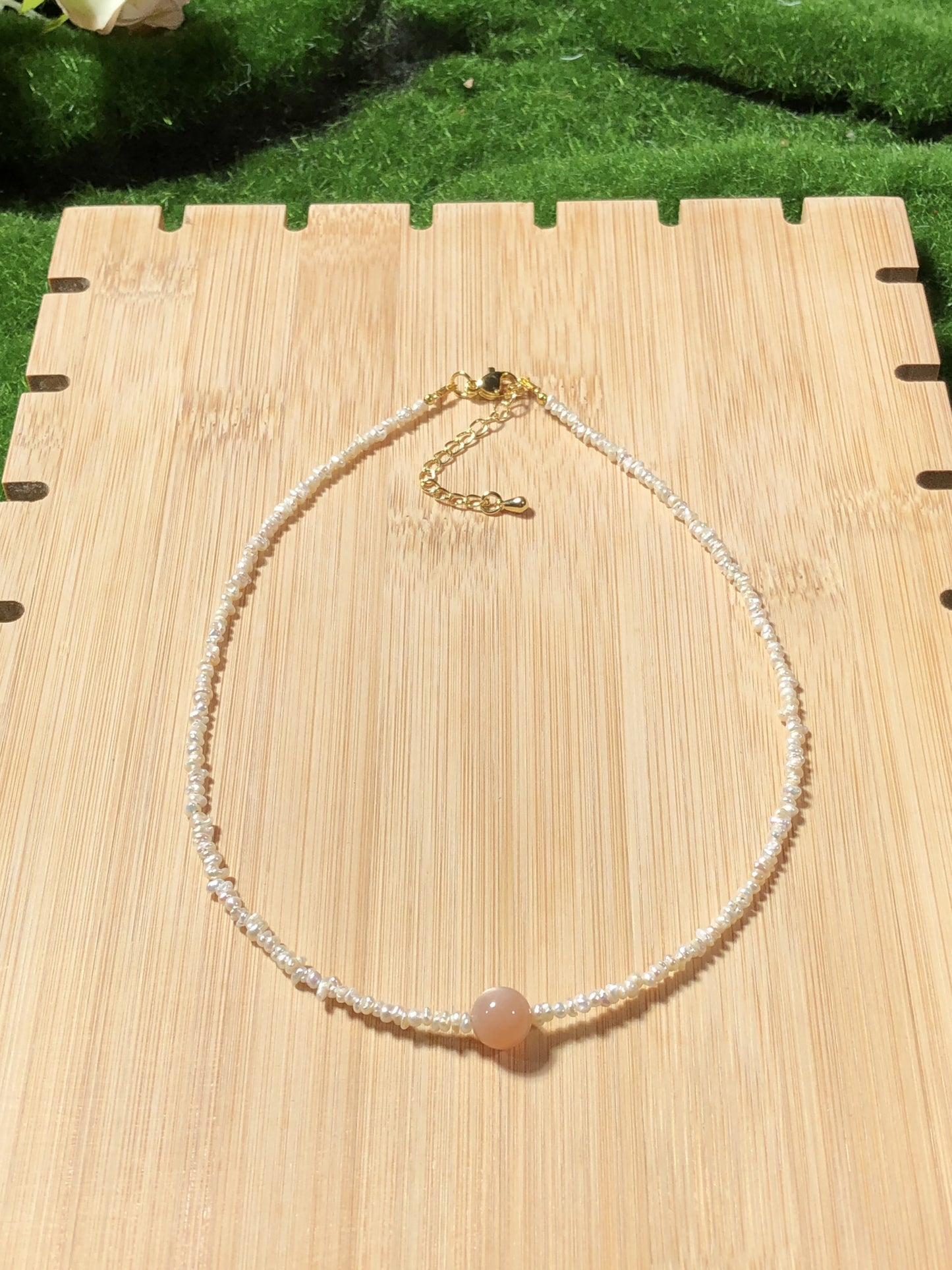 Eine handgefertigte Halskette mit natürlichen Süßwasserperlen und natürlichem goldenem Sonnenstein.