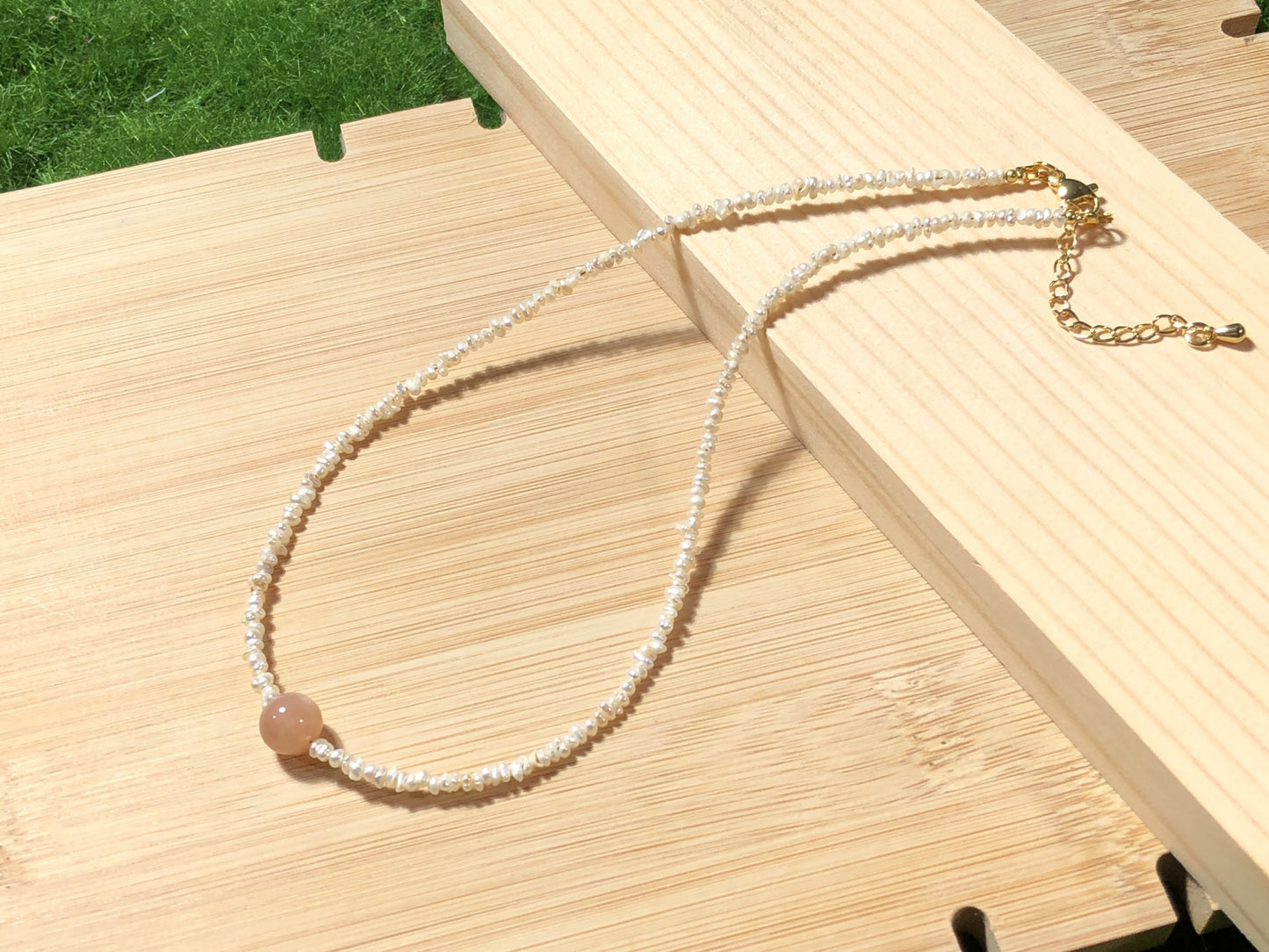 Eine handgefertigte Halskette mit natürlichen Süßwasserperlen und natürlichem goldenem Sonnenstein.