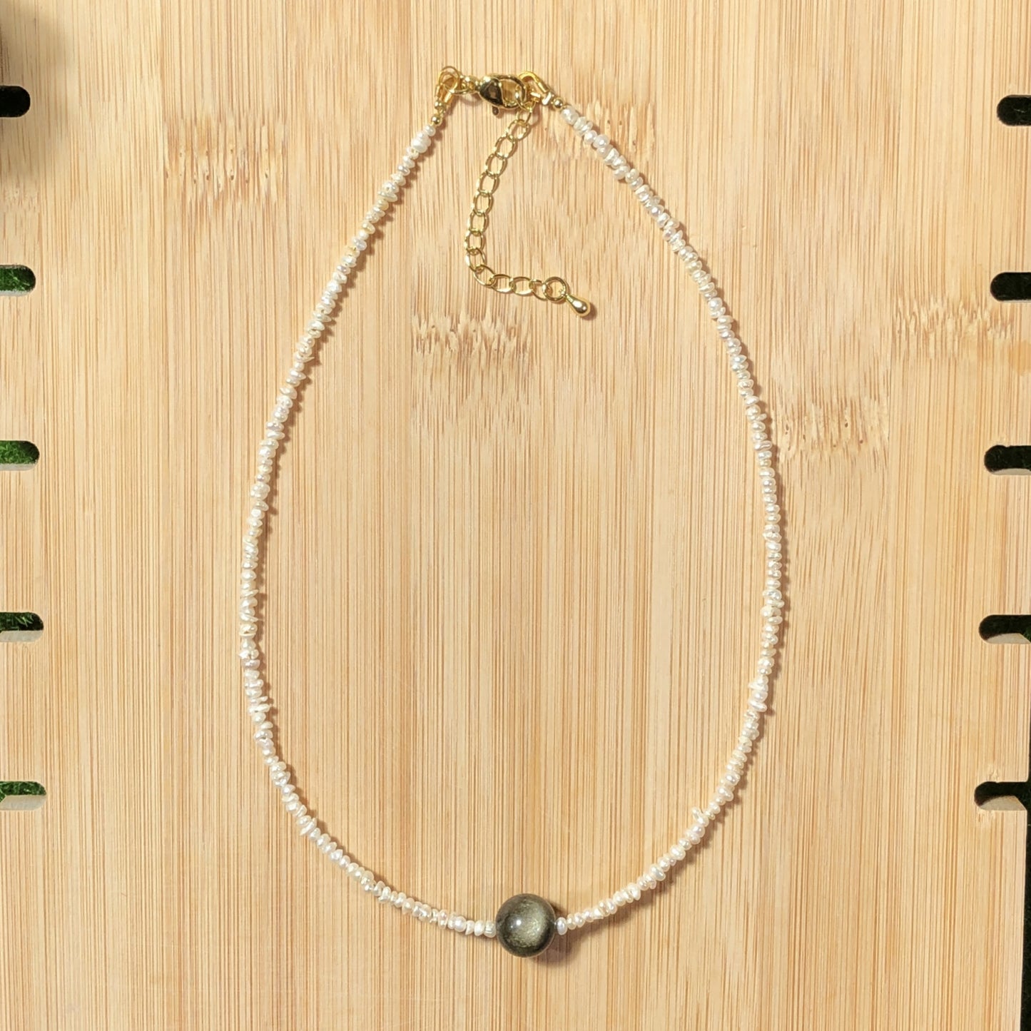 Eine handgefertigte Halskette aus natürlichen Süßwasserperlen und natürlichem Goldobsidian.