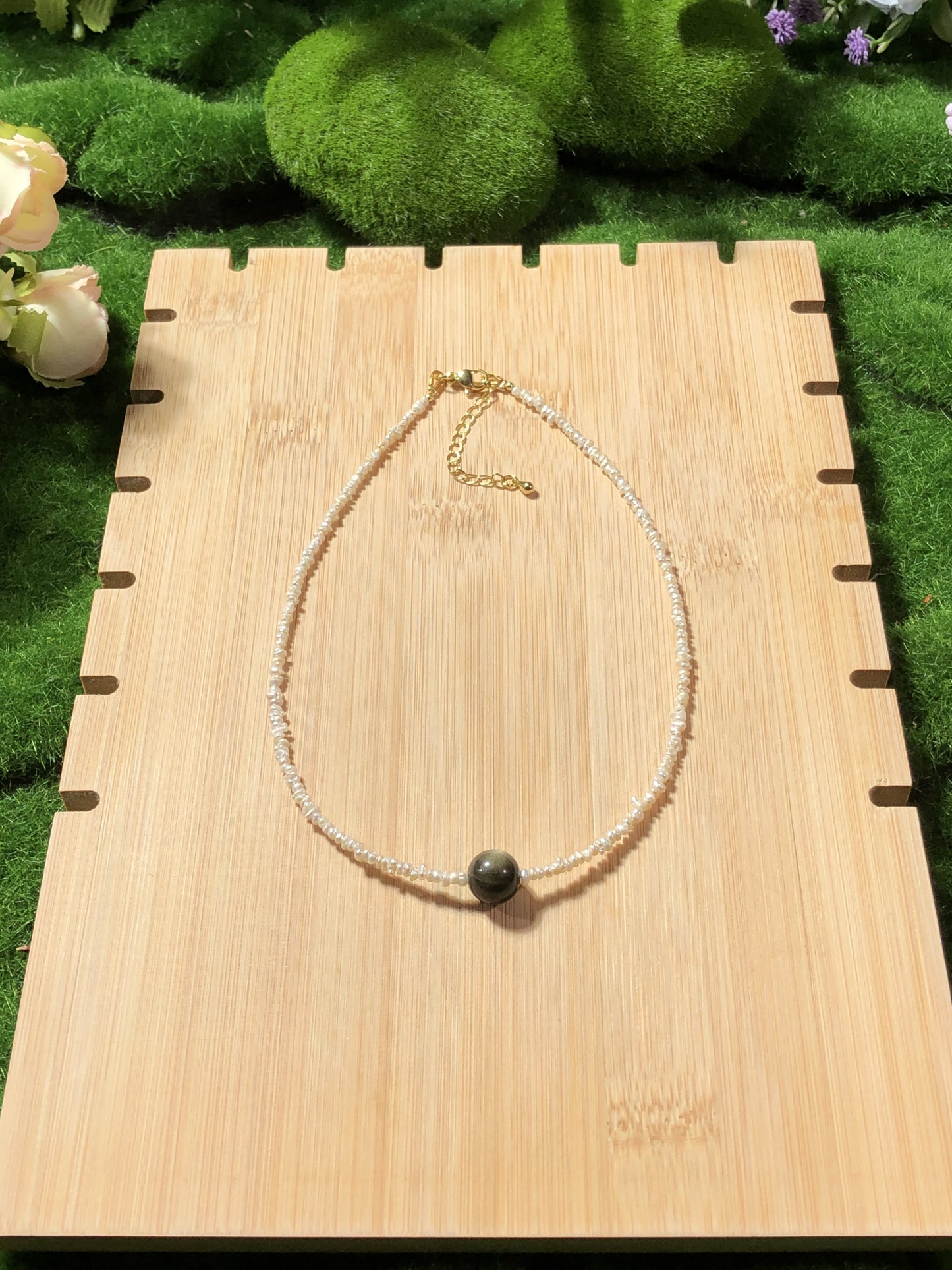 Eine handgefertigte Halskette aus natürlichen Süßwasserperlen und natürlichem Goldobsidian.