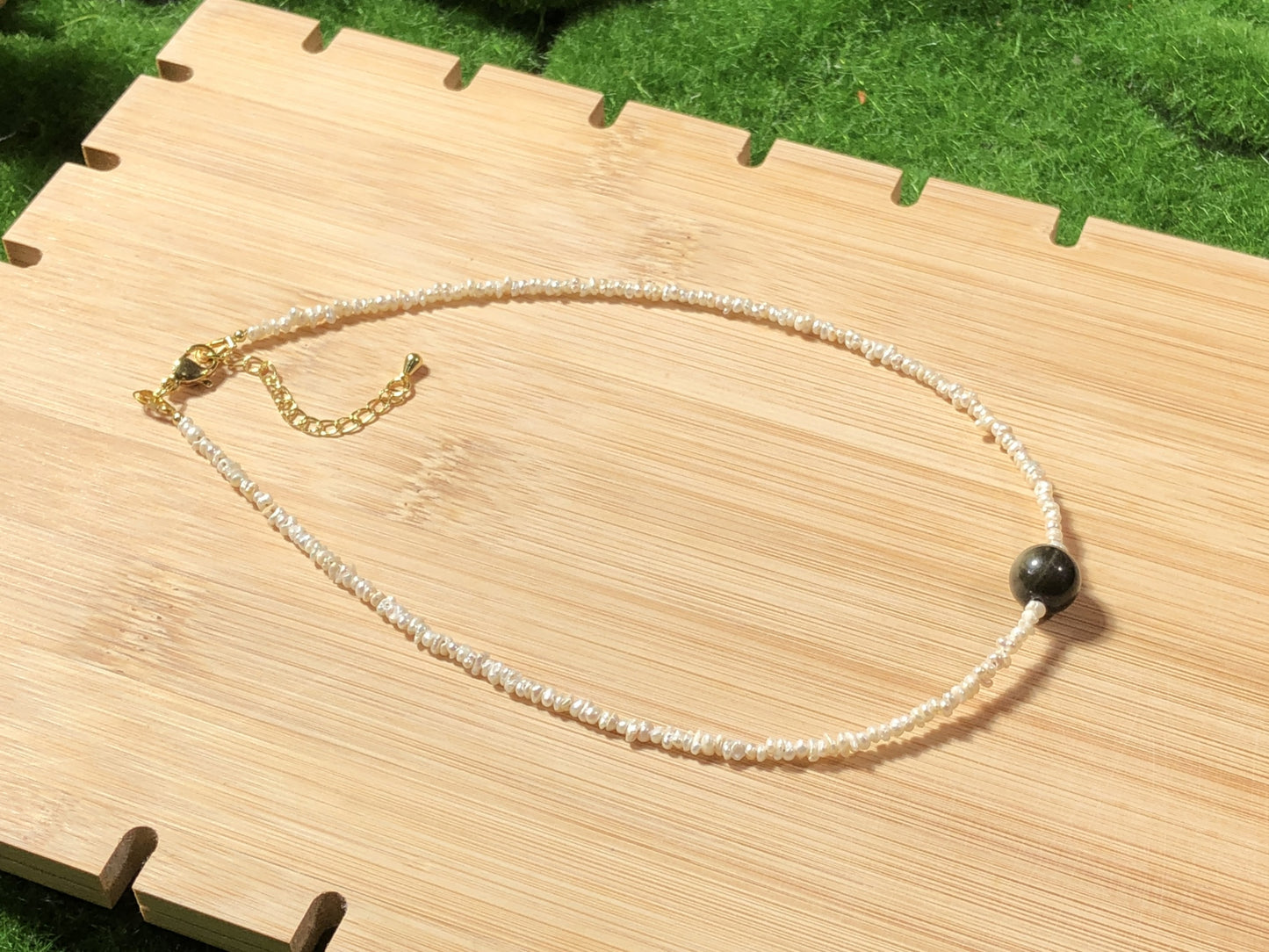Eine handgefertigte Halskette aus natürlichen Süßwasserperlen und natürlichem Goldobsidian.