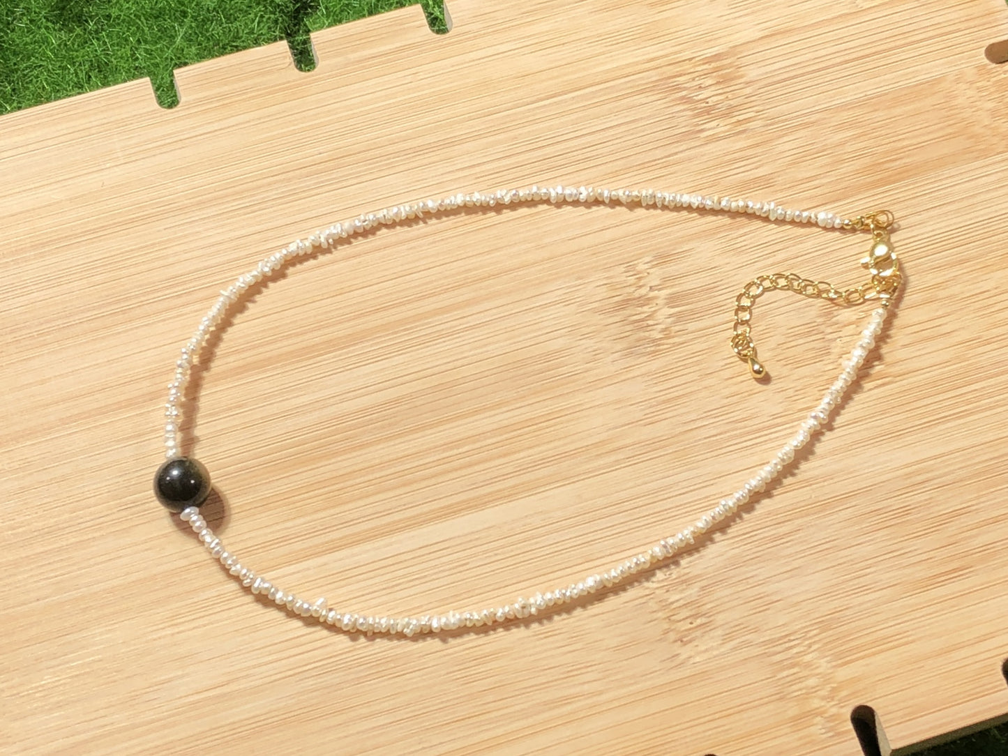 Eine handgefertigte Halskette aus natürlichen Süßwasserperlen und natürlichem Goldobsidian.