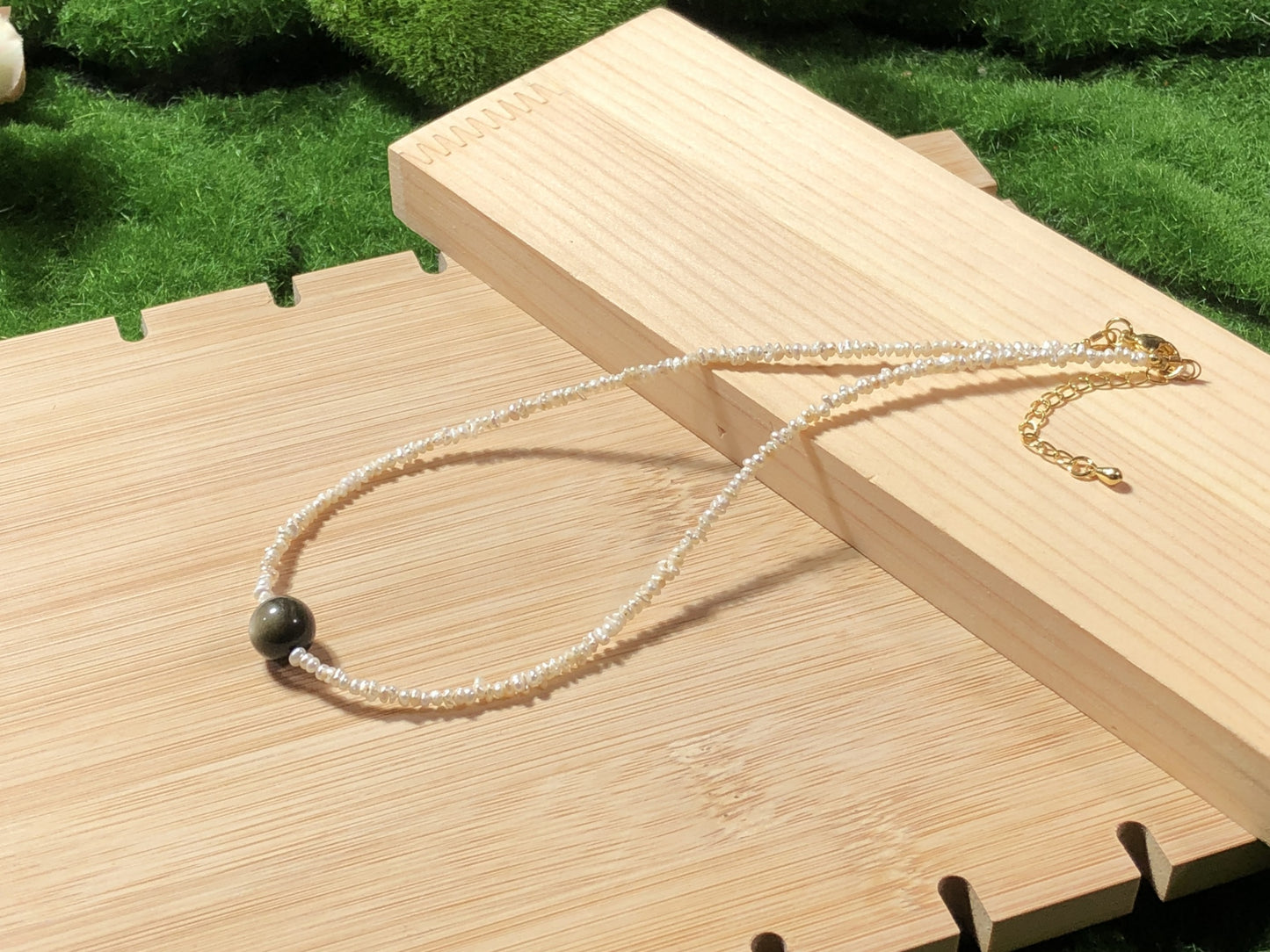 Eine handgefertigte Halskette aus natürlichen Süßwasserperlen und natürlichem Goldobsidian.