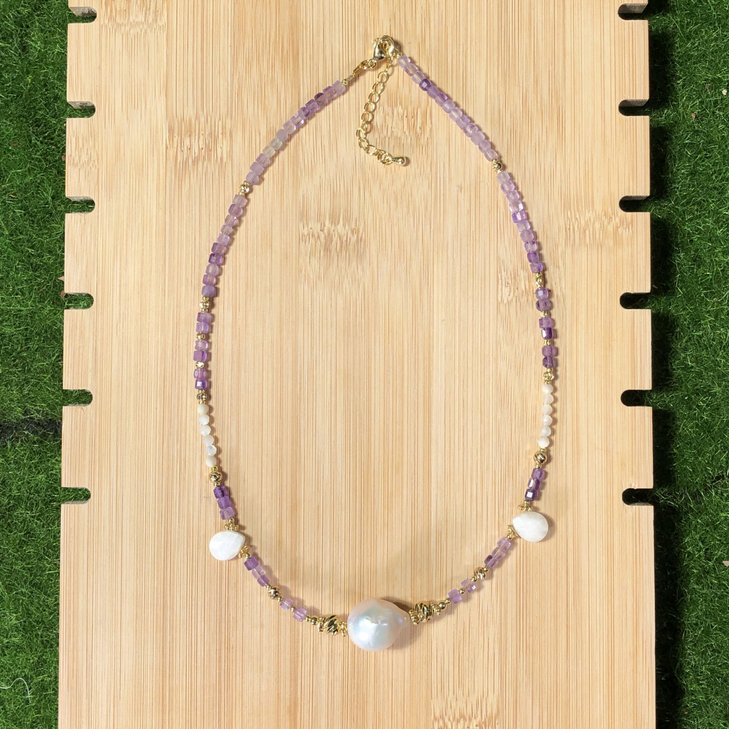 Eine handgefertigte Halskette aus natürlichen Barockperlen und Amethysten, kombiniert mit einer 14-karätig kupferplattierten Goldkette.