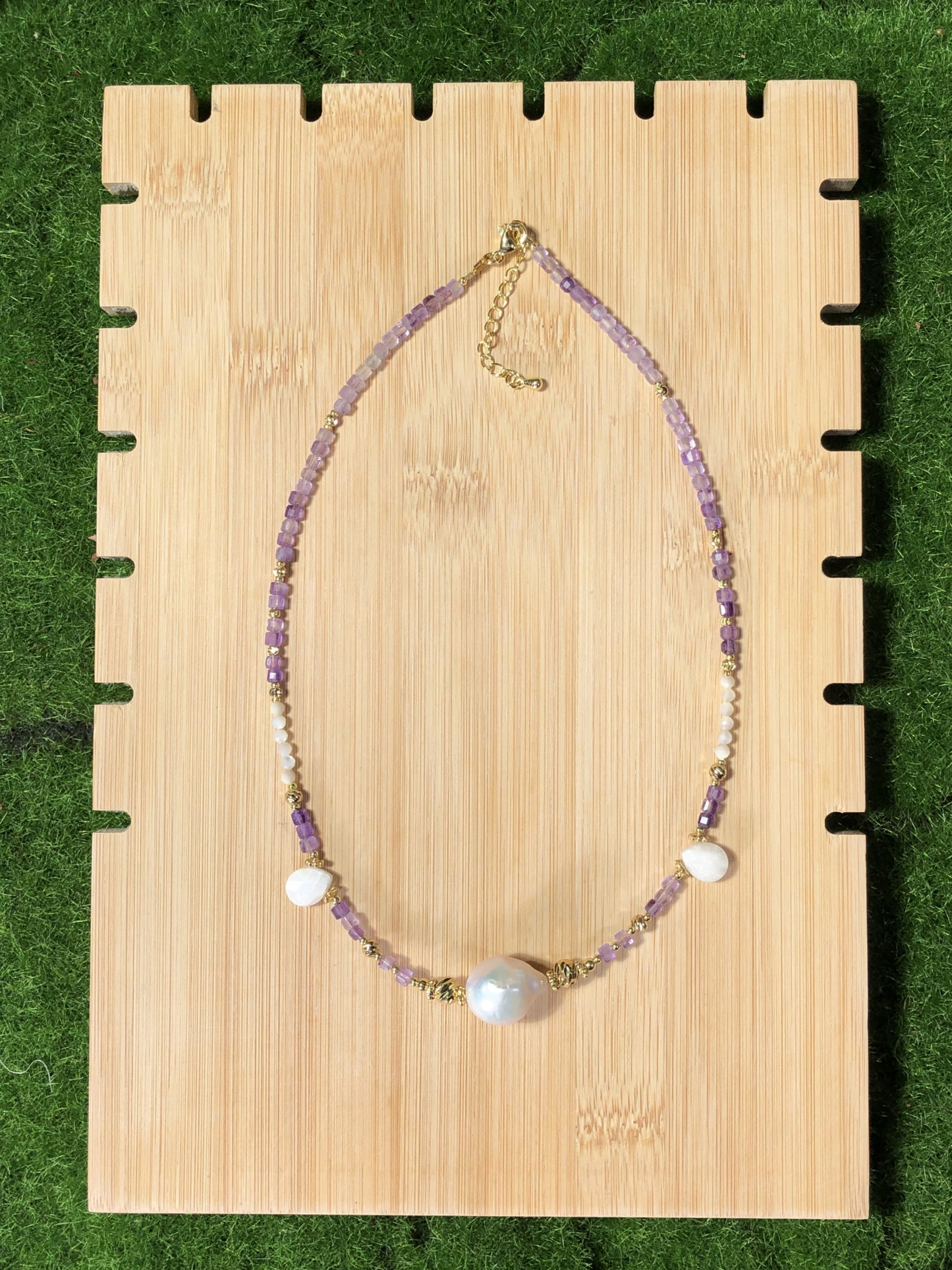 Eine handgefertigte Halskette aus natürlichen Barockperlen und Amethysten, kombiniert mit einer 14-karätig kupferplattierten Goldkette.