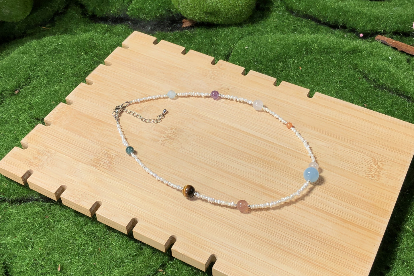 Halskette aus natürlichen Süßwasserperlen und farbigen Edelsteinen mit den acht Planetenmotiven, handgefertigt.