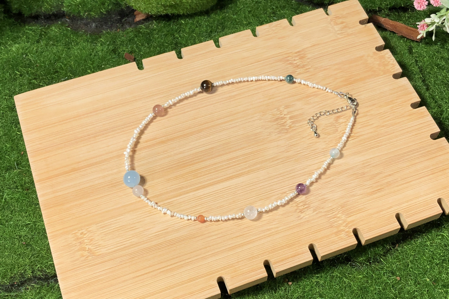 Halskette aus natürlichen Süßwasserperlen und farbigen Edelsteinen mit den acht Planetenmotiven, handgefertigt.