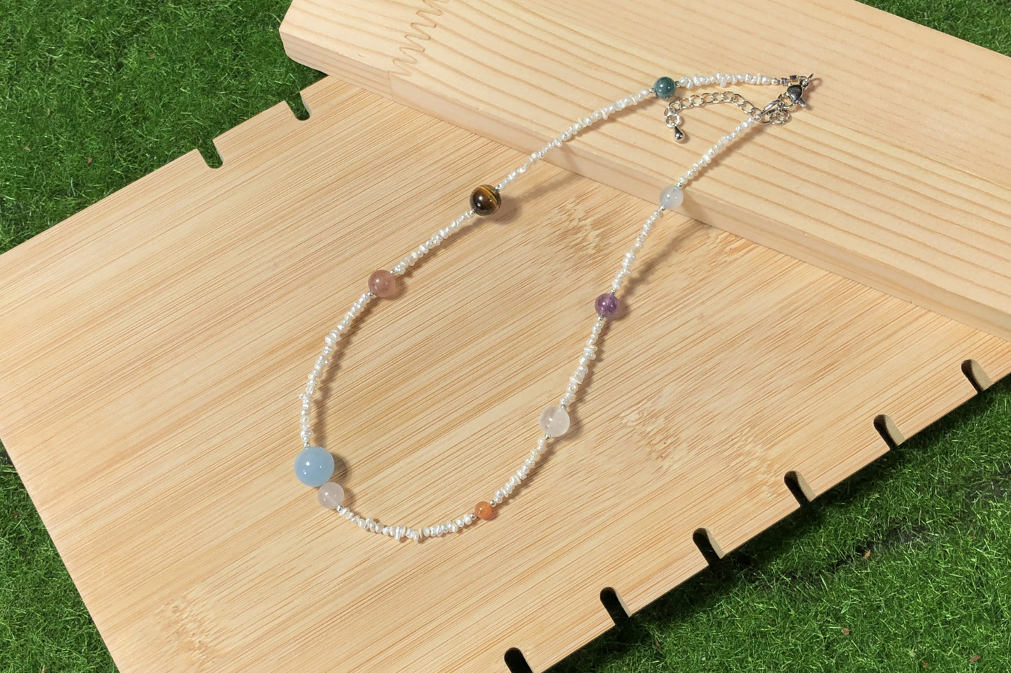 Halskette aus natürlichen Süßwasserperlen und farbigen Edelsteinen mit den acht Planetenmotiven, handgefertigt.