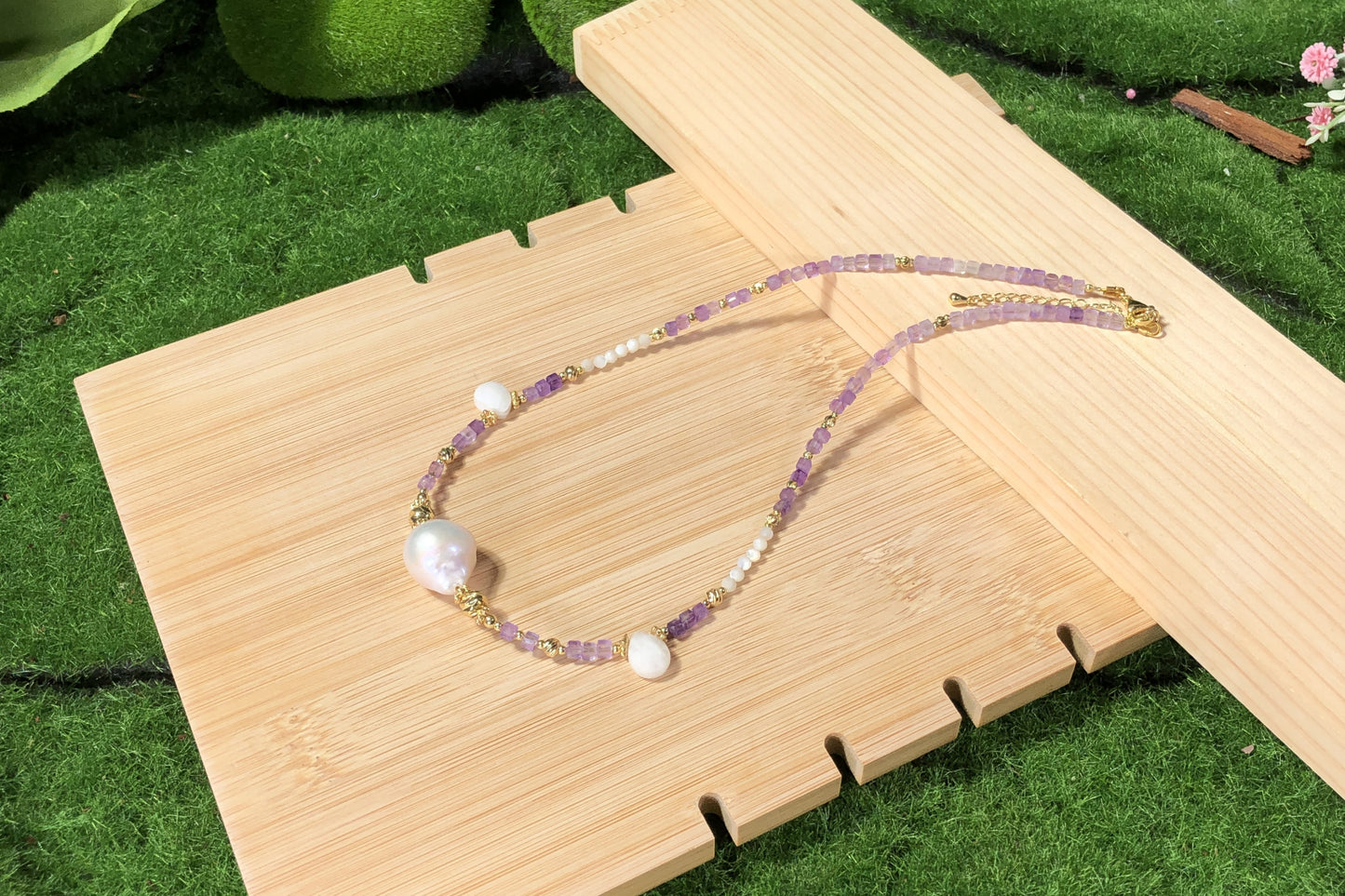 Eine handgefertigte Halskette aus natürlichen Barockperlen und Amethysten, kombiniert mit einer 14-karätig kupferplattierten Goldkette.