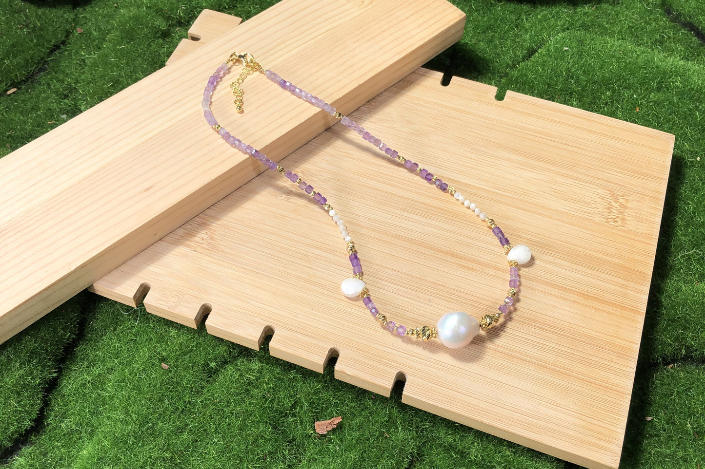 Eine handgefertigte Halskette aus natürlichen Barockperlen und Amethysten, kombiniert mit einer 14-karätig kupferplattierten Goldkette.