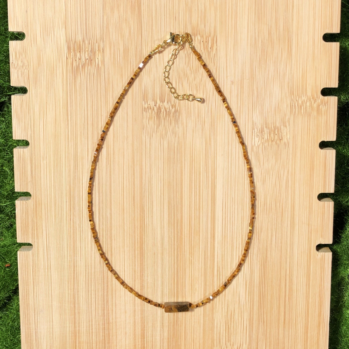 Dieses handgefertigte Schmuckstück besteht aus quadratischen Perlen aus natürlichem Tigerauge und einem rechteckigen Anhänger aus quadratischen Perlen.